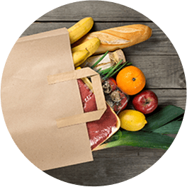 Grocery bag with produce items on wooden tabletop