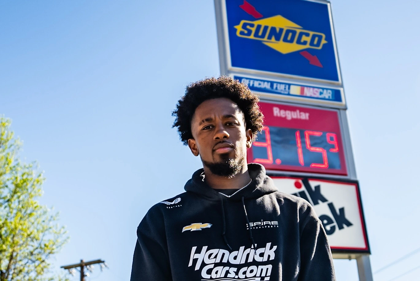Raja Caruth posing in front of Sunoco sign