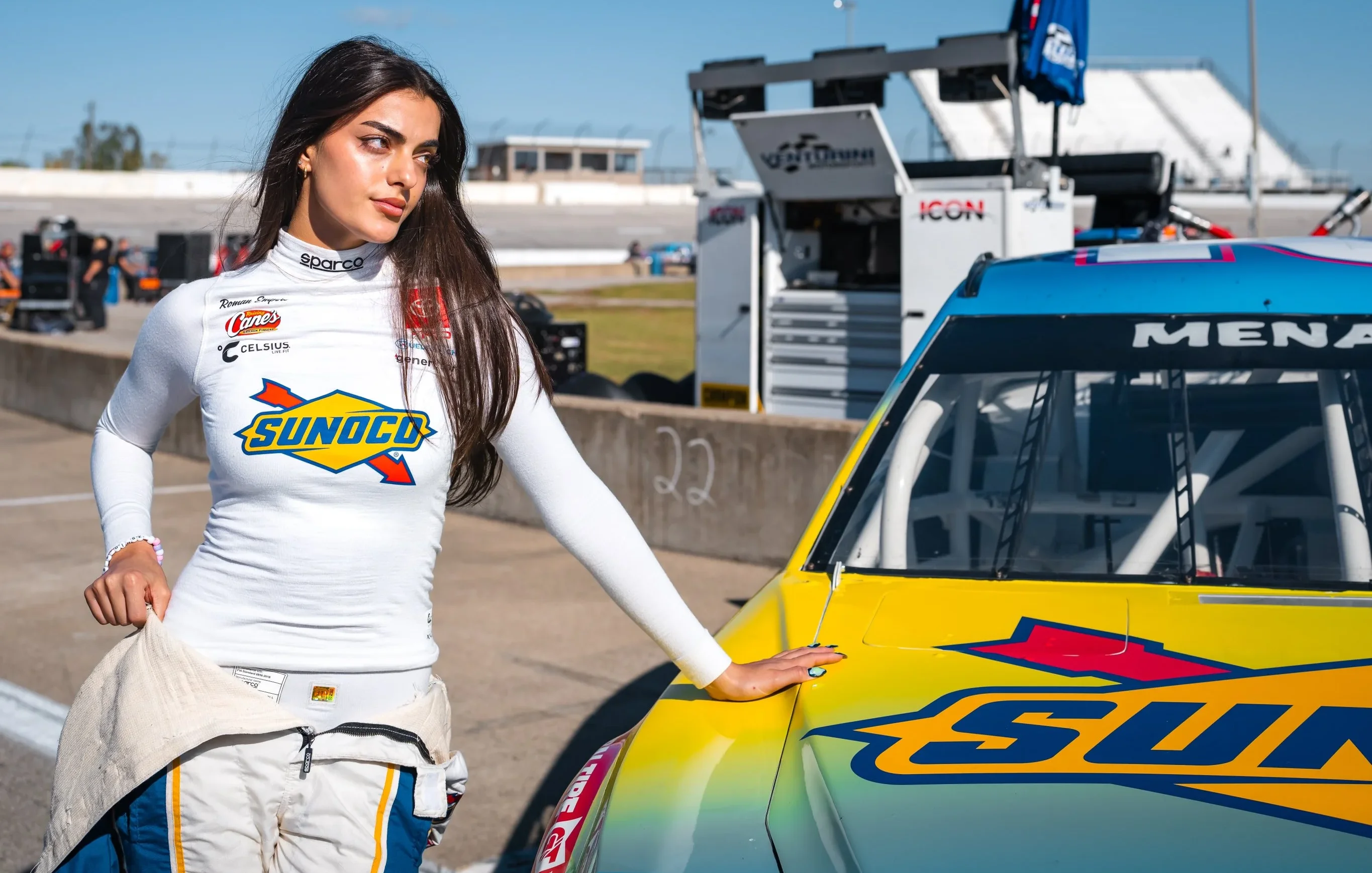 Toni Breidinger posing next to race car