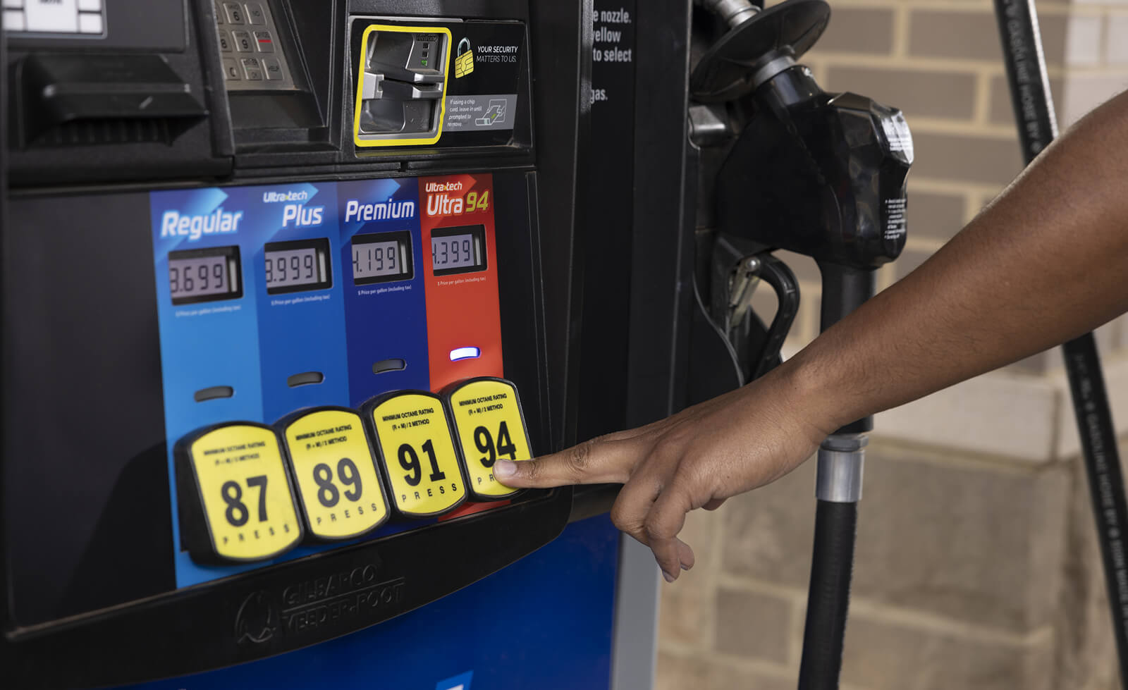 Hand selecting fuel grade at a Pump Dispenser