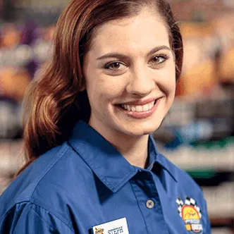 A woman in a Sunoco shirt at a gas station