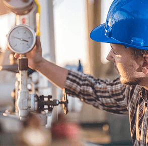 Worker wearing a hardhat checking a fuel gage